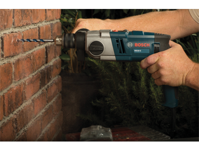 Bosch HD18-2 drill being used to drill a hole in a brick wall.