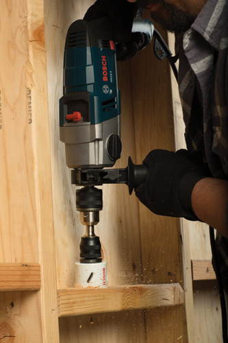 Man using a Bosch HD18-2 drill to drill a hole in wooden planks.