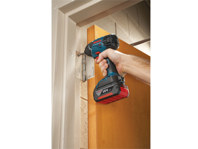 Bosch 18V impact driver being used to install a hinge on a door frame.