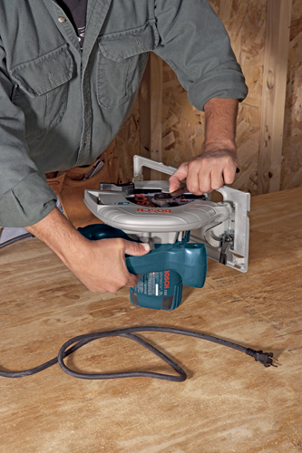 Bosch CS5 circular saw, with a power cord, being used by a person.
