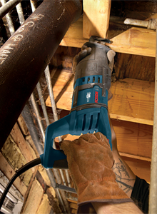 Bosch reciprocating saw cutting wood, with gloved hands and visible tattoo.