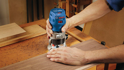 Bosch Colt 1.0 HP router cuts wood, with the model number GKF125CE.