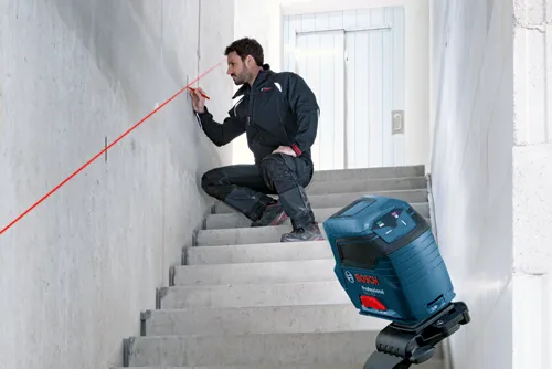 Bosch cross line laser being used on a stairway.