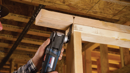 Bosch oscillating multi-tool cutting a wooden beam.