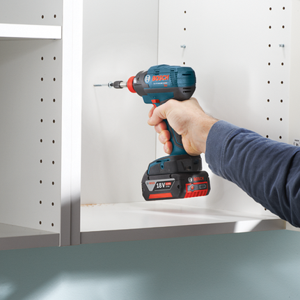 Bosch Lithium-Ion cordless drill screwing into a white cabinet shelf, with 18V 4.0Ah battery.