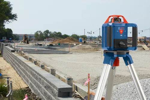 Bosch Professional GRL1000-20HV laser level on a tripod at a construction site.
