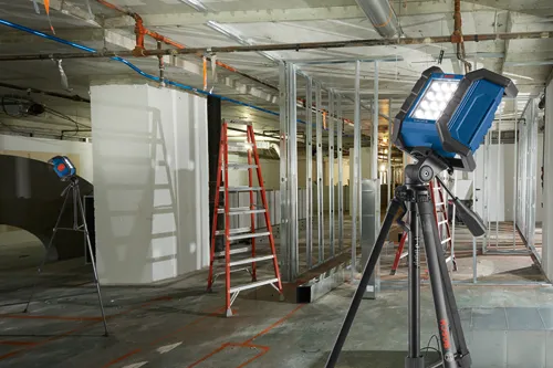 Bosch GLI18V-1200C work light, on tripod, in construction site.