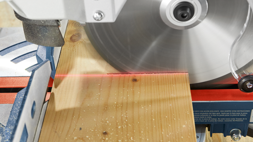 Circular saw cutting a wooden plank, with a red laser guide.