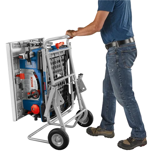 A person in jeans and a blue shirt rolls a Bosch GTA47W Gravity Rise table saw on wheels.