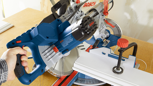 Bosch blue and silver miter saw, with warning text visible.