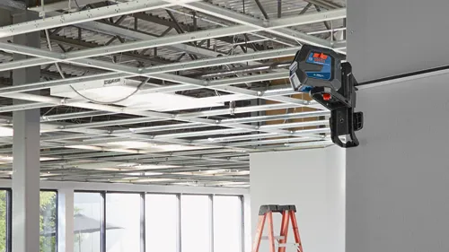 Bosch Professional GLL 100-80CG Green Laser level, attached to a wall, in a construction environment.