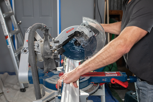 Bosch electric miter saw, with a person operating it.