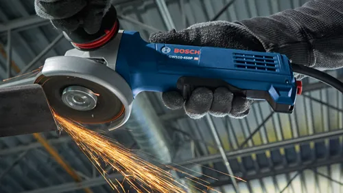 Bosch GWS10-450P HD angle grinder in use, creating sparks while cutting metal.