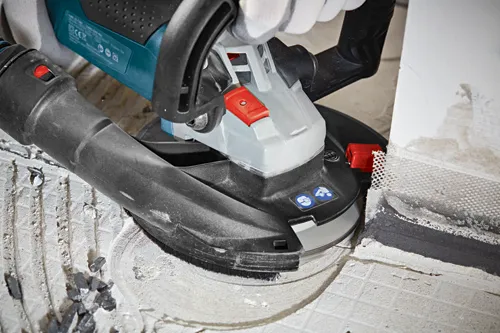 Bosch angle grinder being used to grind a surface. Visible text: GWS 15-CAG, 1 601 C26 001, 125mm V14.