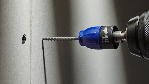 The Dimpler tool screwing into a wall.