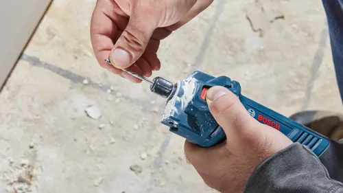 Man holding a drill with "BOSCH" visible on it.