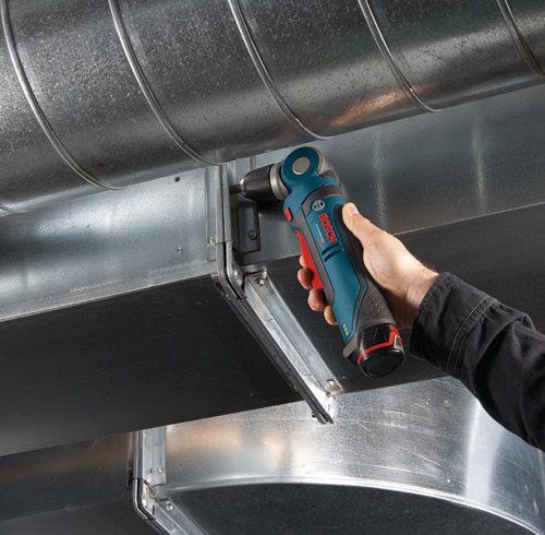 Bosch cordless right angle drill is held by a person against metallic ductwork.