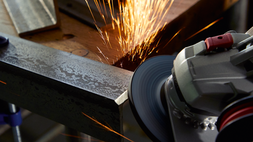 Sparks flying from metal being ground by a power tool.