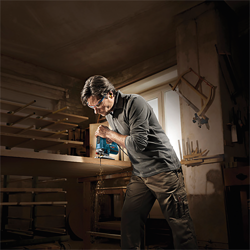 Person using a jigsaw in a workshop.