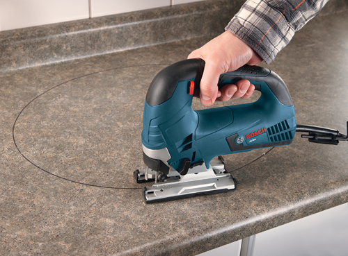 Bosch JS365 jigsaw being used to cut a circle into a countertop.
