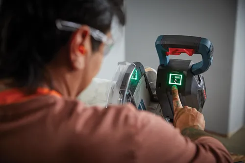Person touching a Bosch TURBO brushless power tool control panel with a green lit "2" display.