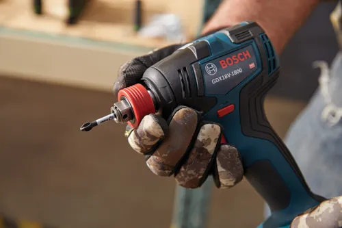 Bosch GDX18V-1800 impact driver, held in gloved hand.