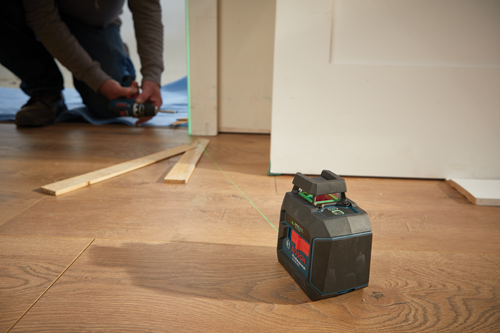 Bosch Professional GLL 5-40 G Green Laser, a person is using a drill in the background.