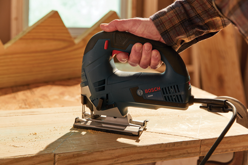 Man in a workshop using a Bosch corded jigsaw to cut stair stringers.