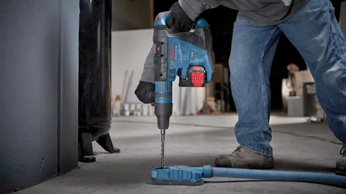 Bosch GBH18V-40C, BITURBO BRUSHLESS hammer drill in use, person wearing jeans, black gloves.