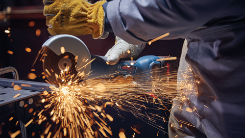 Bosch GWX18V-10P HD angle grinder in use, creating sparks while cutting metal.