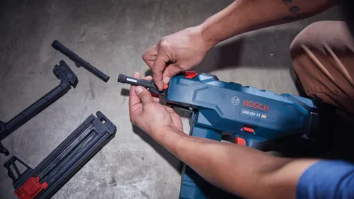 Person assembling a Bosch GNB18V-12 HD nail gun.