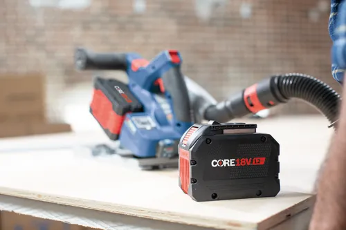CORE 18V 12Ah battery next to a blue and red circular saw, and a flexible tube.
