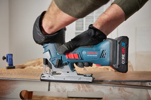 Bosch GST18V-50B HD jigsaw, with CORE 18V 4Ah battery, being used by a person wearing gloves.