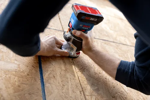 Bosch GKF18V-25 Colt cordless palm router being used on wood.