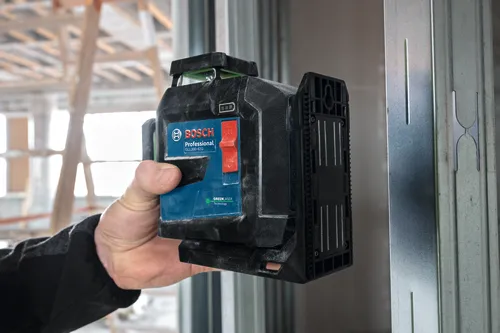 Bosch GLL300-42G level held by a person.  Visible text: "BOSCH Professional GLL300-42G GREEN LASER Technology".