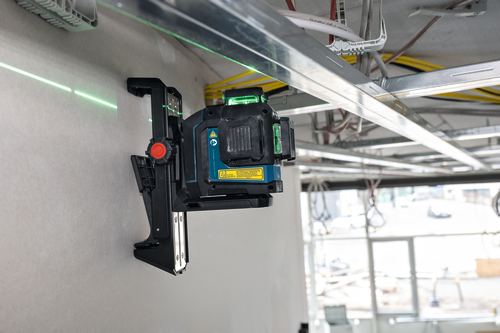 Bosch laser level tool, mounted on a wall with green laser line visible, with text "Canada ICES-003(B)/NMB-003 (B)", "IEC 60825-1-2014 <10 mW, 500-540 nm", and laser safety warning.