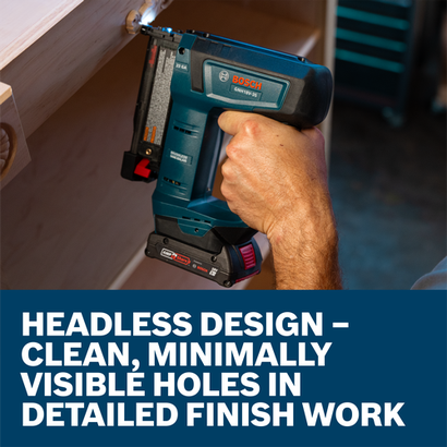 A worker holding a Bosch 18V 23-Gauge Pin Nailer to install shelving.