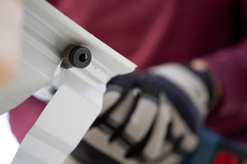 The worker using the GNA18V-16E 18V 16-Gauge Nibbler With Lock-On Slide Switch to cutting a polycarbonate tile.