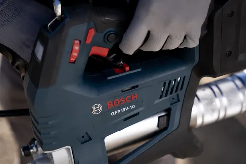 A worker using the Bosch GFP18V-10 18V Grease Gun on a close-up visualization.