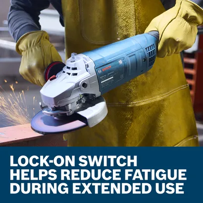 The worker using the Bosch GWS22-180J 7 In. Large Angle Grinder to grind the edge of a piece of metal in a work shop.