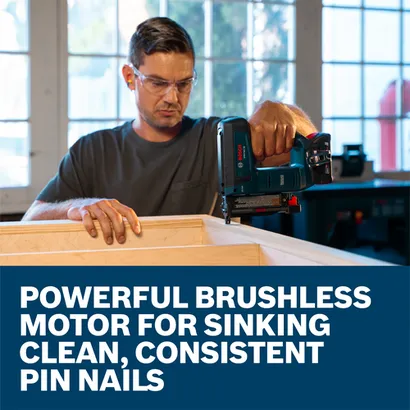 The worker using the Bosch GNH18V-35N 18V Brushless 23 Gauge Pin Nailer to nail the corner of the wooden furniture.