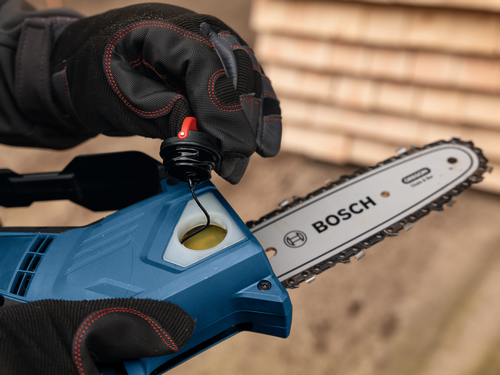Close-up image of worker removing the cap of Bosch GKE18V-20 18V Pruning Saw.