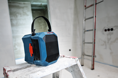 Image of Bosch GPB18V-1CN 18V Jobsite Bluetooth® Speaker on top of a ladder, in the middle of a room under renovation.