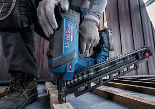 Image of worker using the Bosch EXNH18V-90MRN EXPERT 18V Framing Nailer on a wooden strips.