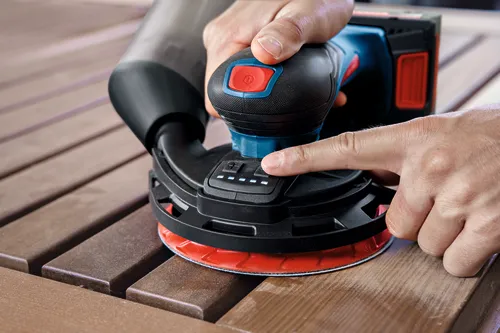 Image of worker using the Bosch EXEX18V-150-5N Random Orbit 18V 6” Random Orbit Sander (3/16”) for finishing a wooden strips.