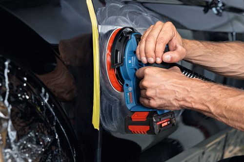 Image of worker using the Bosch GEX18V-150-3N 18V 6” Random Orbit Sander (3/32”) for finishing a car.