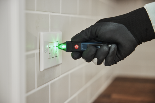 Application Image of worker using the Bosch GVD1000-15 Non-Contact Voltage Tester to test the voltage of an outlet.