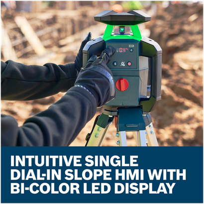 A worker in gloves adjusting the slope on a Bosch GRL18V-34K rotary laser level on a tripod at a construction site.