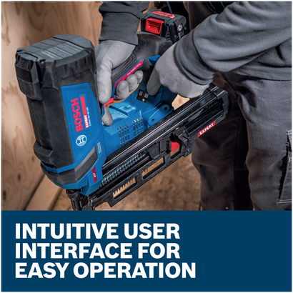 A worker wearing gloves holding a blue Bosch EXNH18V-90MRN EXPERT Framing Nailer on an interior residential jobsite.