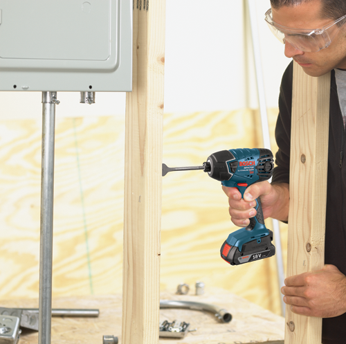 Voici la traduction :

Visseuse à chocs Bosch IMPCTOR LITHIUM-ION 18V utilisée par une personne portant des lunettes de sécurité pour visser une vis dans une montant en bois.